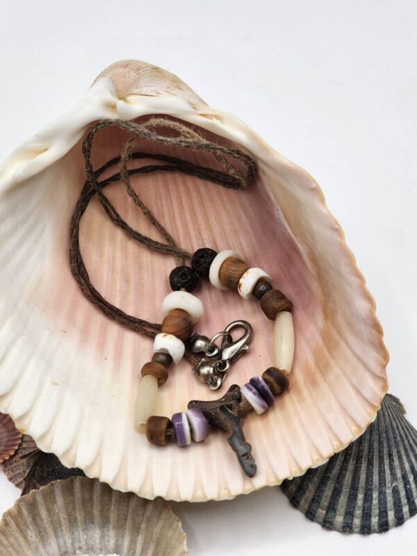 Shark carved from fossil shark tooth on a necklace with shell, wood, and bone beads.